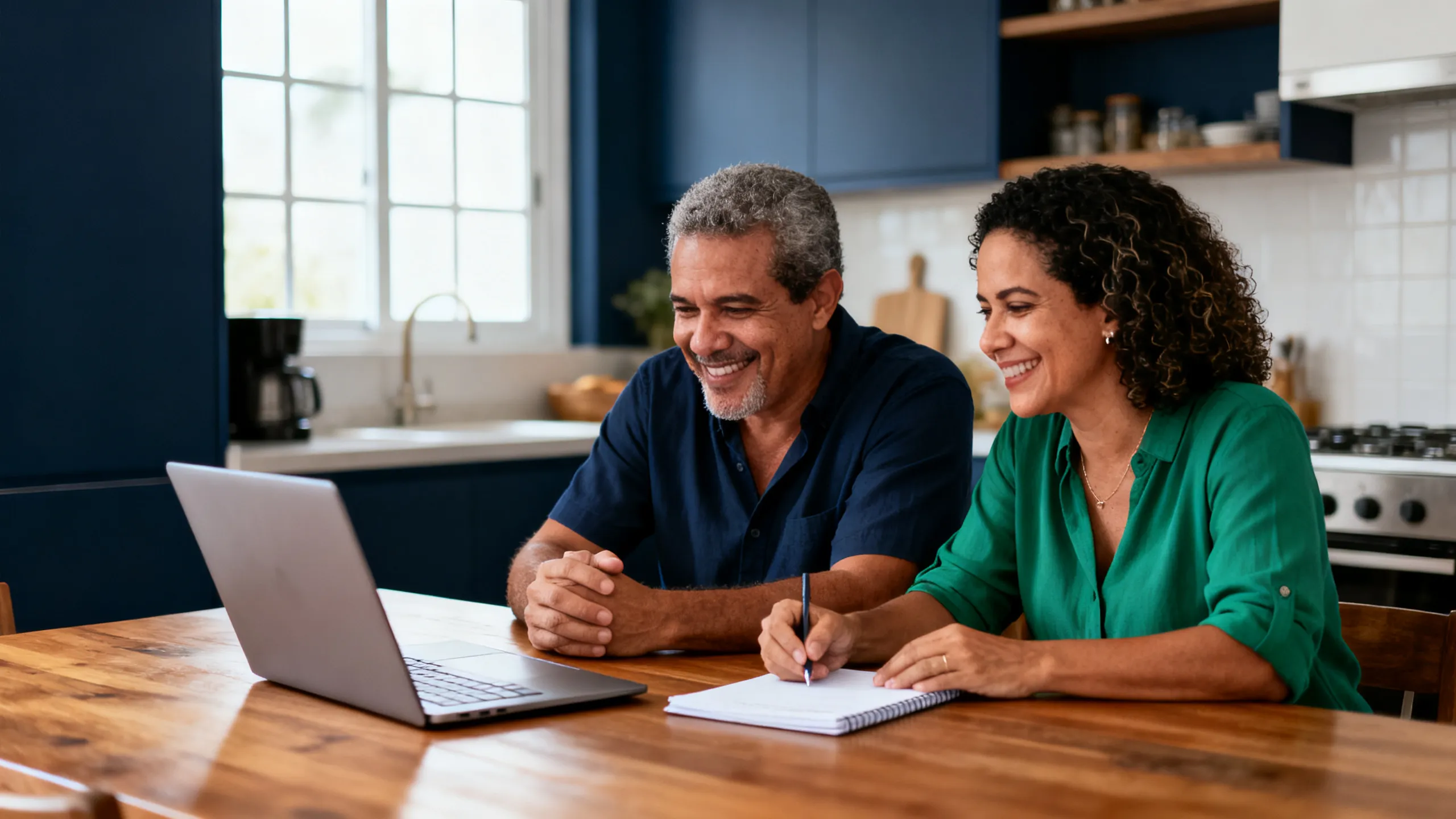 Casal em casa planejando o orçamento com tranquilidade, usando notebook e caderno.